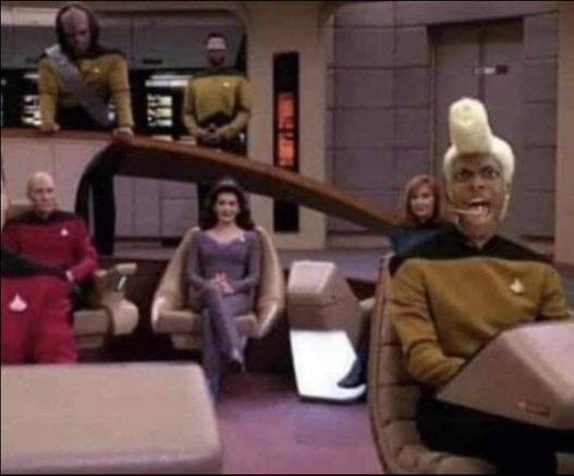 The deck of the ST:TNG Enterprise. The crew is at their station. Ruby Rod from the 5th Element is seated at the con.