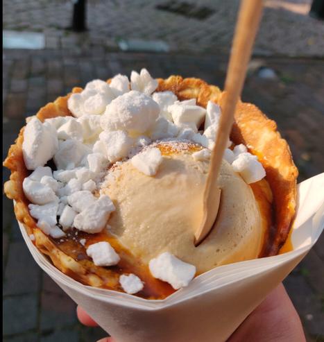 Riesige Eiskugel in riesiger Waffel mit salziges Karamell Soße und Baiser-Stücken