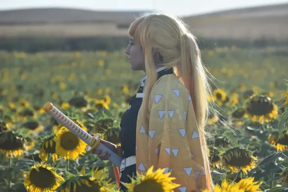 Aparezco con el cosplay de Zenitsu mirando hacia un lado en un campo de girasoles