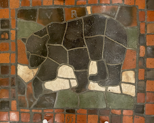 multicolor floor tile mosaic, side profile of a black bear, labeled “URSUS” and numbered “95”