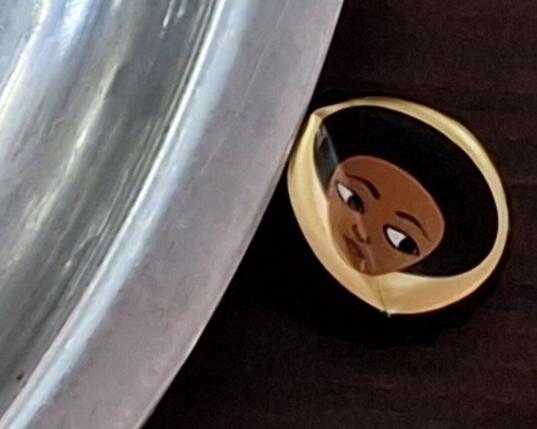 Habesha beer cap showing woman looking askance.