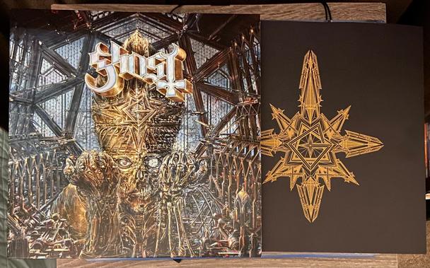 Closeup of the album cover for Impera by Ghost, laying slightly on top of the included beautiful lyric and picture booklet.