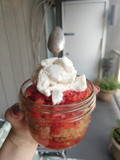 Strawberry shortcake dessert in a clear mason jar in outdoor environment