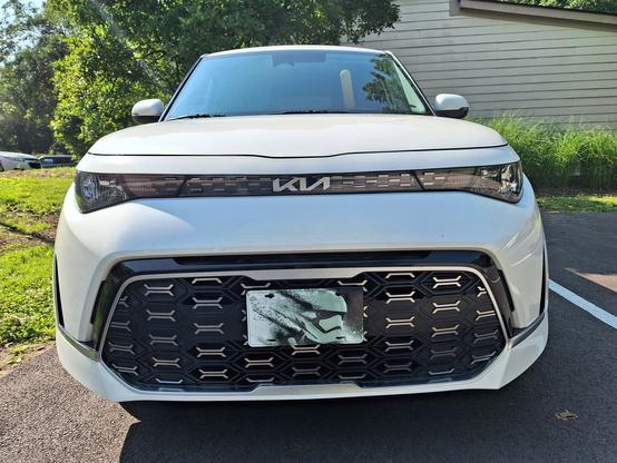 Front view of a white 2023 Kia Soul with a vanity plate of a First Order stormtrooper helmet