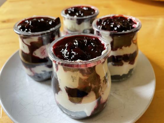 Four small layered parfaits in glasses.