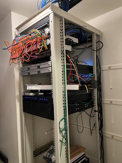 Our new full-height server rack, complete with switches, terrible cabling, and two xserves!