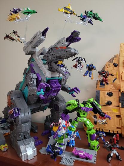 A photo of a large number of Transformers figures on a shelf, most of which are very small. Many of the figures pictured are Seekers, in robot mode or jet mode, on flight stands.