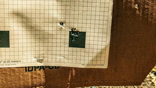 Five shot impacts on a target sheet, four of which are in or touching the black and one flier is about a half inch high and to the left.