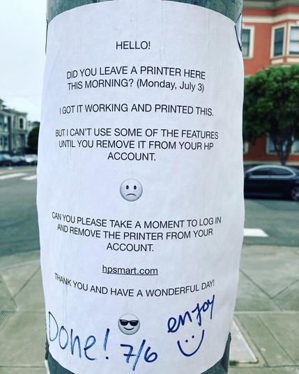 A flyer posted on a utility pole asking for help with a printer left out there to share and an indication the needed action was taken