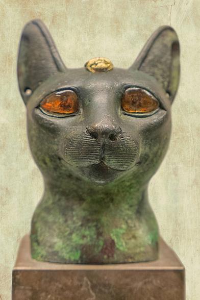 This cat’s bronze head with amber eyes has a golden scarab inlaid on the forehead. It was part of a cat-shaped sarcophagus for a cat mummy, as a sacrifice to the Goddess Bastet in Egypt ca. 600 BC