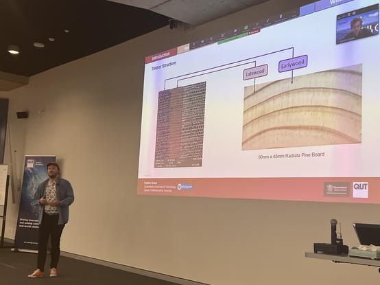 Patrick presenting his talk with a slide showing a cross-section of timber