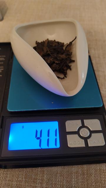 A white chahe containing tea on a precision scale showing "4.11g"