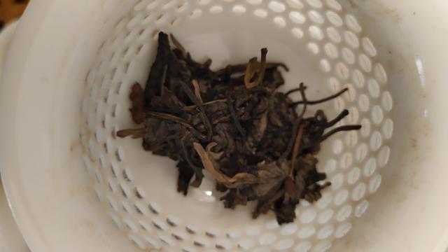 Compacted tea leaves at the bottom of a white gaiwan