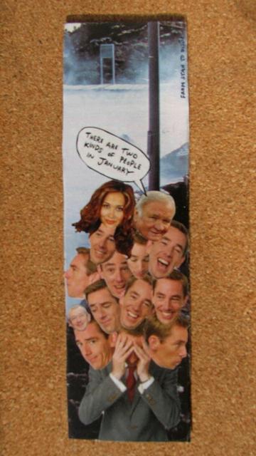 Rectangular bookmark made from paper on cardboard. It features a cut-out of TV/radio presenter Ryan Tubridy, who is currently embroiled in a scandal over hidden payments by the state broadcaster. He is wearing a grey suit and holding his face in his hands. But sprouting from his head, in every direction, are a cluster of 10 other Ryan Tubridy heads, plus a Myleene Klass head and a Ron Atkinson head. A speech bubble from Ron says, 'There are two kinds of people in January.' One Tubridy has a small Louis Walsh head on his forehead. The backdrop is unclear but seems to show a pole and a distant sign on snowy ground.