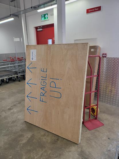 A large box, very clearly labeled "FRAGILE UP!" with arrows pointing in the intended upwards direction. Except they're pointing sideways, because the box is on its side.