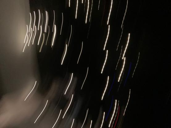 Blurry picture of a black background with yellowish streaks across the frame