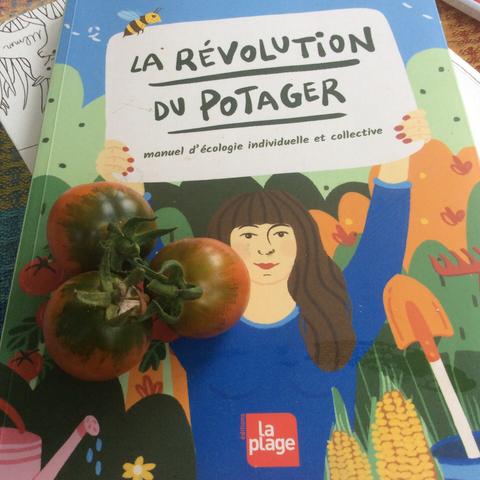 3 petites tomates rouges posée sur le livre "la révolution du potager"