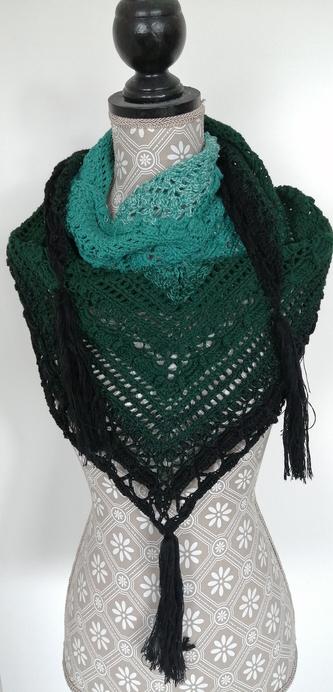 Ful view of a triangular scarf with green gradient and tassels at the ends wrapped around a mannequin.