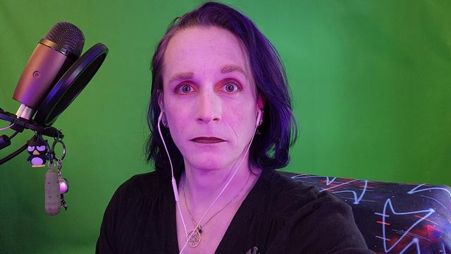 a non-binary space cat in front of a green screen