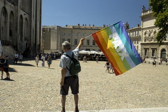 Manifestant avec le drapeau de la paix devant le Palais des Papes