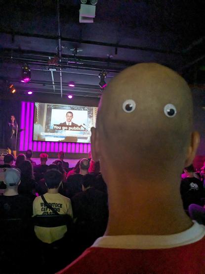 SummerCon Staff Member with googly eyes glued on the back of his head.