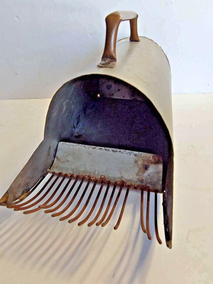 Flattened prongs extend out of a half cylinder made of metal. There is a handle on the top.