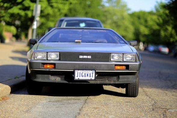 Picture of the front of a DMC DeLorean with a Virginia license plate "JIGAWAT"