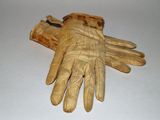 A photo of Lincoln's gloves which have yellowed with age. Near the cuffs are visible blood stains.