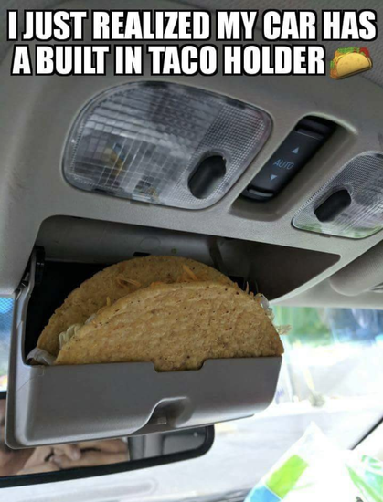 Meme! Photo of a car's overhead/interior light area, sunglasses holder is hanging open with a hard-shelled taco resting in it, caption reads I JUST REALIZED MY CAR HAS A BUILT IN TACO HOLDER