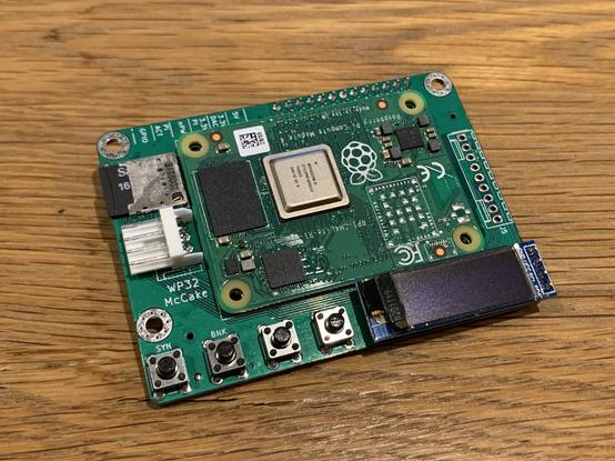 Small green PCB with four buttons and an OLED display.
