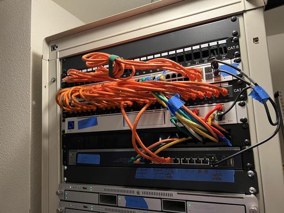A rack inside a server room with tidy orange patch cables