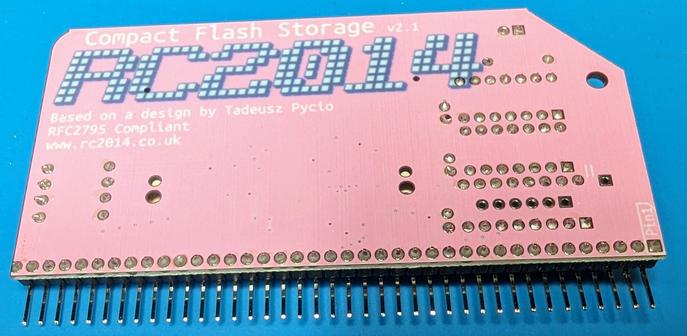 The back side of the pink colored CF card PCB board showing the solder welds