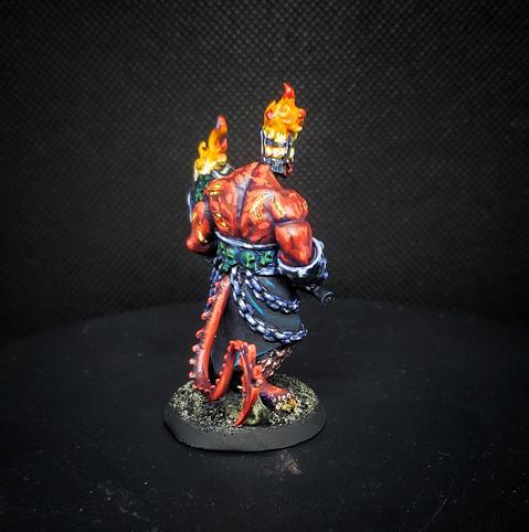 The same miniature from behind, showing off the tail and burning, magma-like scars.