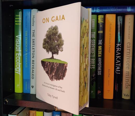 A photo of Toby Tyrrell's book On Gaia, heavily annotated with yellow post-it notes. The book is standing on a shelf with various other biology books.