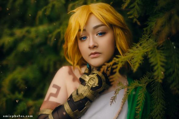 Zelden cosplaying as Link from The Legend of Zelda Tears of the Kingdom, leaning against foliage with the decayed hand against neck