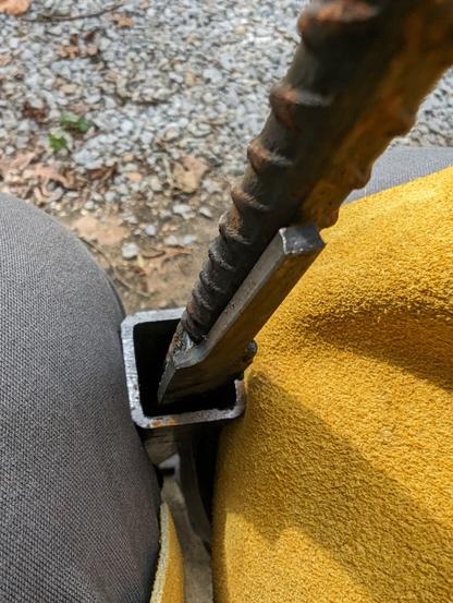 A piece of rebar with an old flat file welded to it. The whole contraption is in side a 1.25" square tube, which sits between my legs for stability while filing.