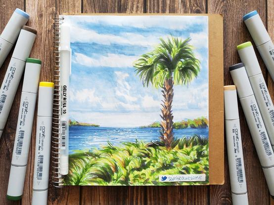 A Copic marker sketch drawing of a palm tree and other greenery with the ocean and a blue cloudy sky behind them. All eight markers (+one gel pen) used to make the artwork are pictured beside it.