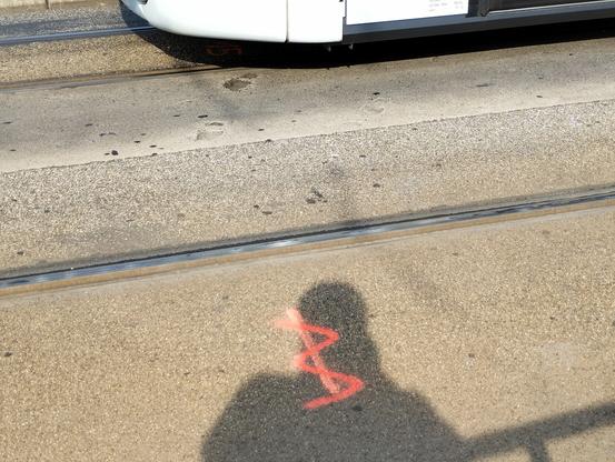 Fußabdrücke auf dem Beton eines Tramgleises