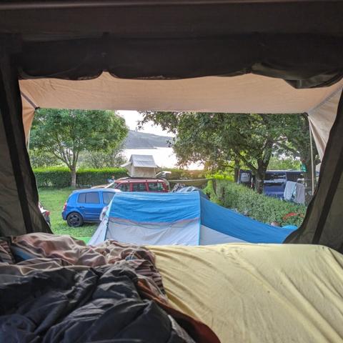 view from rooftop tent over camping ground to sea