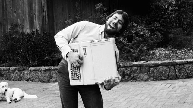 silly bw pic young steve wozniak smiling and holding old mac like an accordion sorta