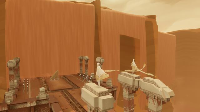 Screenshot from the game Journey with two white robed players hanging out on top of some ruins pillars in front of an enormous sandfall