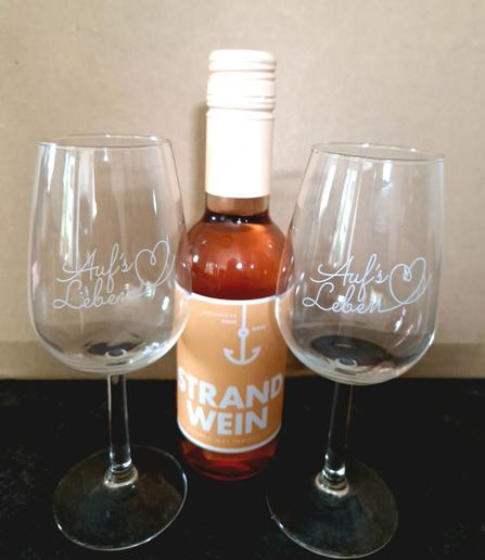 Kleine Flasche Strandwein, zwei Trinkgläser.