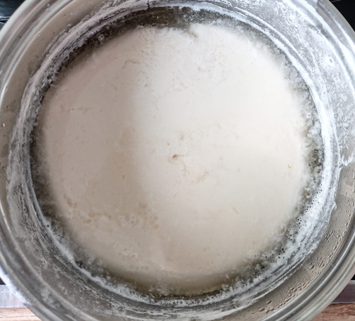 in einem Topf die gesäuerte Milch, man sieht, wie sich die Molke abgesetzt hat.