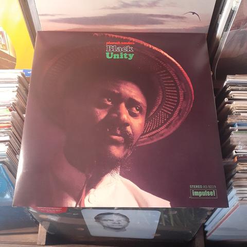 Album cover features photograph of Pharoah Sanders. He is sporting a Fu Manchu-stule beard, a wide brimmed round woven hat, and a high-collared shirt, all of which gives him a distinctively Asian vibe.