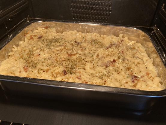 Auflaufform im Backofen mit Käsespätzle und Röstzwiebeln.