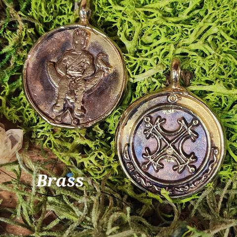 Image of a brass solar talisman showing both the front and back. On the left is the obverse image, with a crowned figure sitting on a throne over a magical symbol, with a raven sitting at his left hand. On the right is the reverse image, with the Agrippan Grand Seal of the Sun in the center and the characters of the sun in an arc along the bottom.