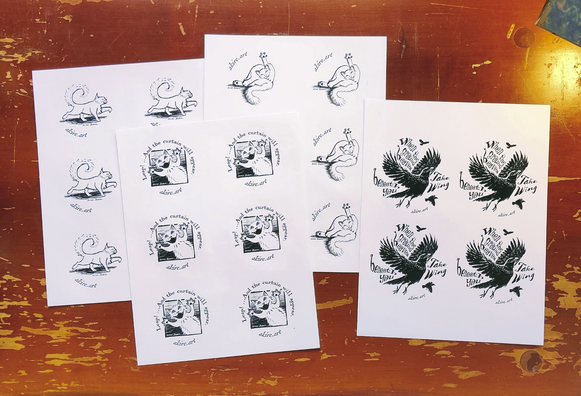 header image: Four sheets of round stickers printed in shiny black ink on a shiny white background, laying on the scratched surface of an old wooden desk. On the left, we see a sheet of 3" stickers showing a cat walking with fluffy tail curled, front paw raised, & hind foot extended backwards, looking elegantly unconcerned. Lying on top of the right side of this is another sheet of 3" stickers. These stickers show a cat from the belly up as she leaps up and to the right, wearing an expression of open-mouthed exuberance. Text arcing above the drawing on this sticker reads, "Leap! ...And the curtain will appear." Sticking out from underneath and to the right of this sheet is a third sheet of 3" stickers showing a cat washing her butt, one hind leg flopped to the side, one leg pointing straight up, tongue extended towards butthole and eyes closed in feline bliss. Laying on top of the right edge of this sheet is a fourth sheet of stickers. These larger stickers show a crow in flight, with wings stretched up and out and legs thrown back, as the crow joyously takes to the air. Distorted text in curly serif and brush fonts surrounds the crow and reads, "When the ground heaves beneath you Take Wing". There are two smaller crows flying in the background above and below the large one.