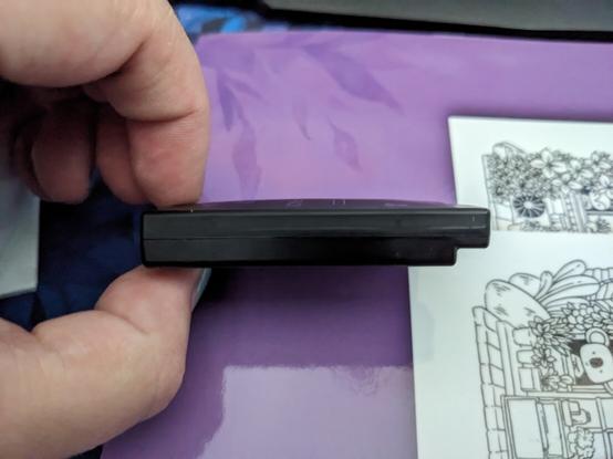 Same black Sony PSP battery, now on it's side to see it bulging on both the top and the bottom.