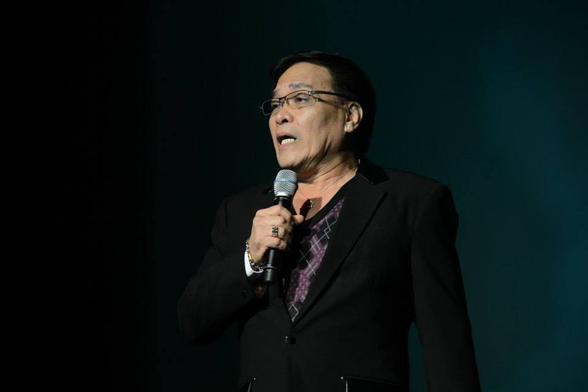 Willie Nepomuceno with a microphone, doing a comedy skit