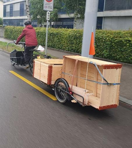 Lastenfahrrad mit zwei grossen SBB Holzkisten auf dem Anhänger.